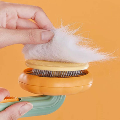 Hand using a pet hair removal tool with collected fur on an orange background