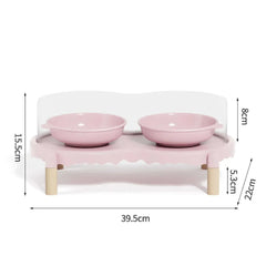 Pink elevated pet feeder with two bowls, wooden legs, and dimensions shown for cats and dogs