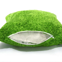 Green textured pillow with a zipper on a white background