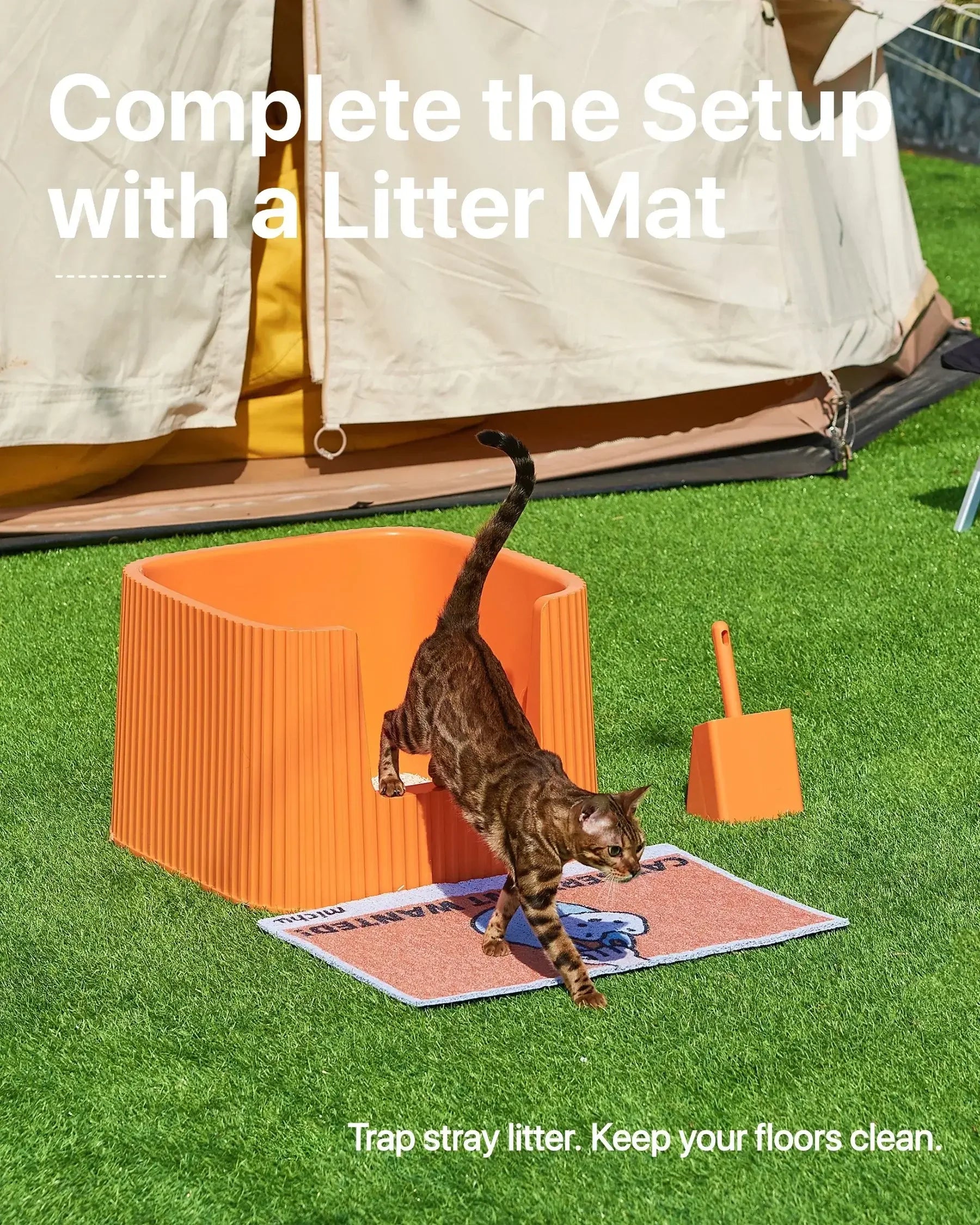 Bengal cat stepping off an orange Michu XXL cat litter box onto a litter mat on green grass.