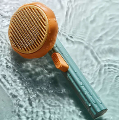 Pet grooming brush with orange bristle head and blue handle on a water surface