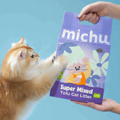 Fluffy ginger cat reaching for Michu Super Mixed Tofu Cat Litter bag, unscented and lightweight for pets.