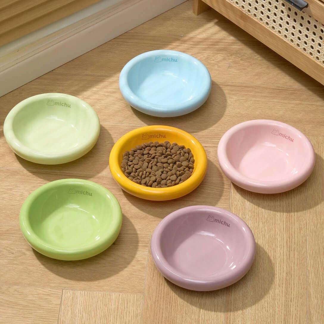 Michu Wide and Shallow Ceramic Pet Bowl in various pastel colors with dry cat food inside