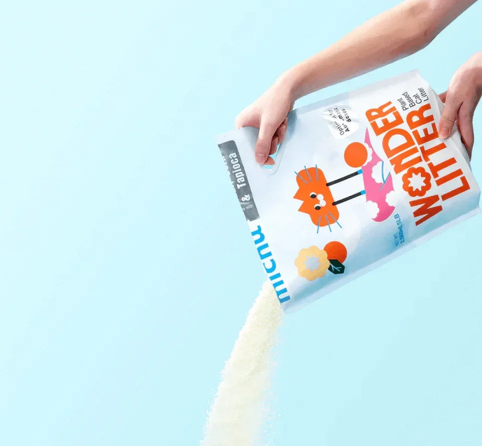 Hands pouring plant-based cat litter from Micnu Wonder Litter bag, eco-friendly & tapioca formula