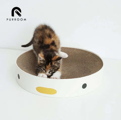 Calico kitten playing in a round cardboard scratcher with cute face design, ideal cat toy and pet supply.