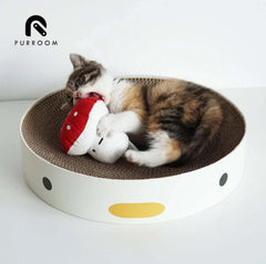 Calico kitten playing with mushroom toy in round cardboard scratcher bed