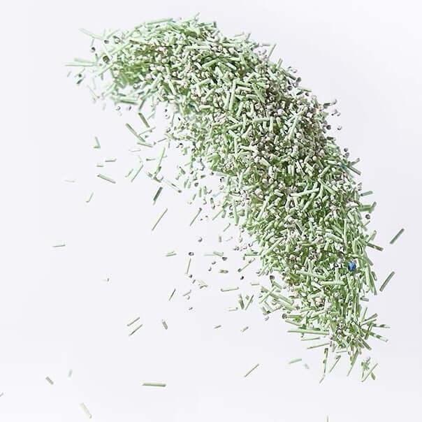 Green cat litter granules with odor control beads for cats, ideal for pet owners seeking clean, practical supplies.