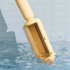 Gold-colored pool vacuum cleaner being used in a swimming pool with water splashing around it.