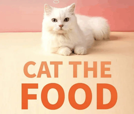 Fluffy white cat lying down with text reading CAT THE FOOD