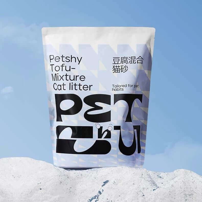 Bag of Petshy Tofu-Mixture Cat litter against a blue sky and white snowy background.