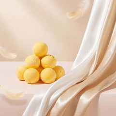 PawDry Freeze-Dried Quail Egg Yolk 100g stacked on soft fabric with feathers, a nutrient-dense cat treat.