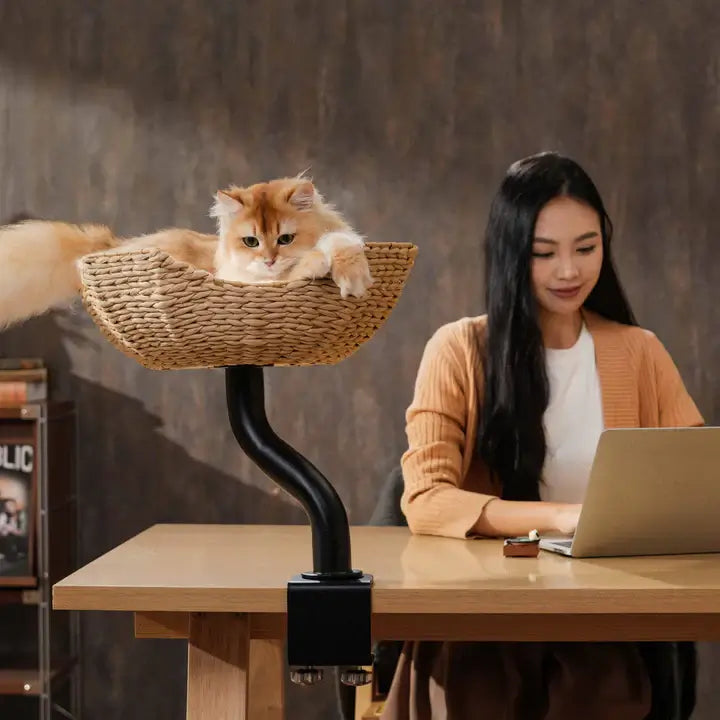 Michu DeskMate Desk-Mounted Cat Tree Perfect For WFH with a cat lounging in a cozy basket beside a woman working.