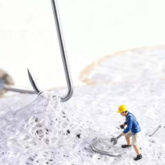 Close-up of a miniature worker using a tool on a pile of white material with a metal hook in the background.